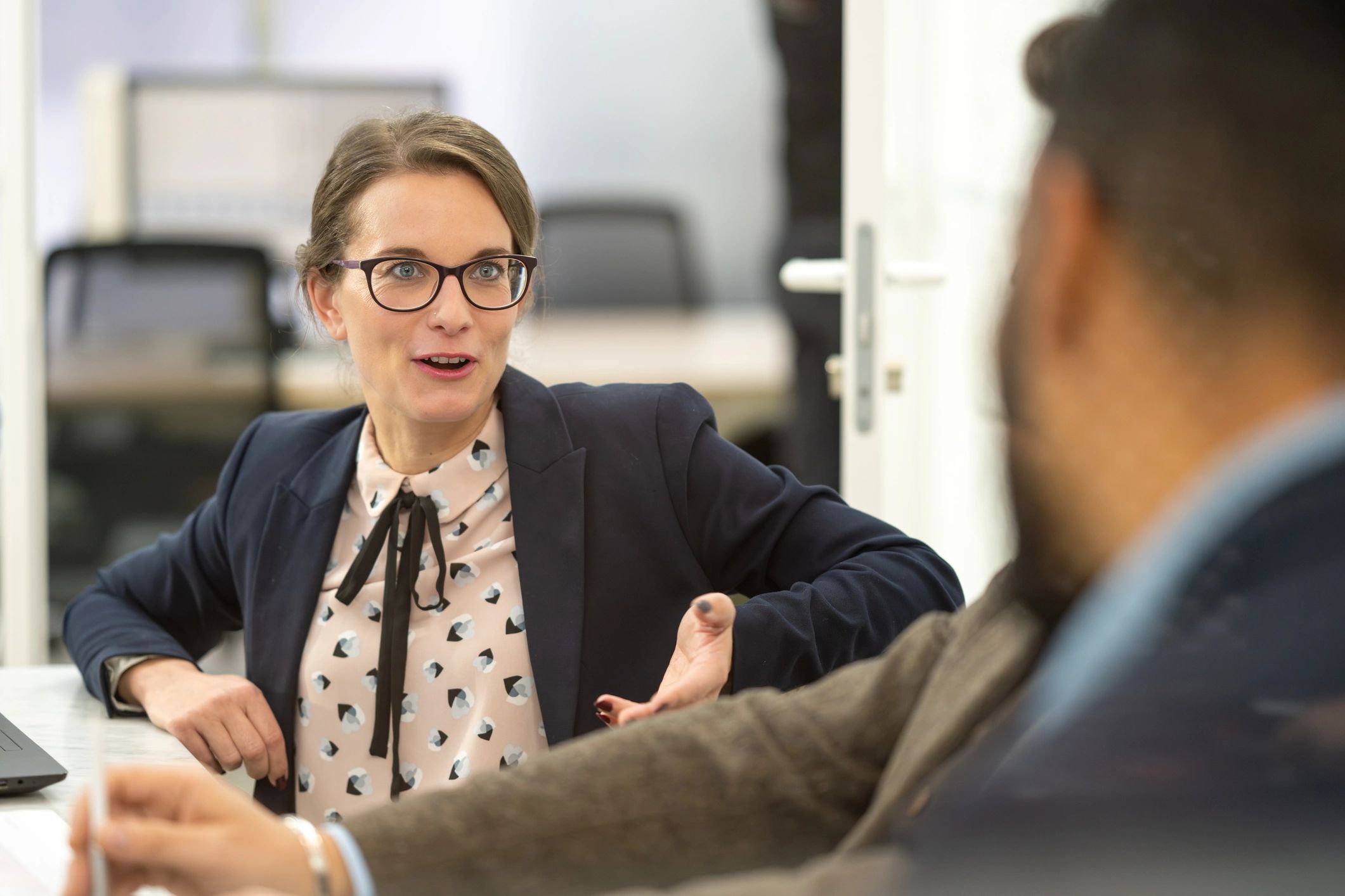 Two colleagues having a positive coaching conversation in an office