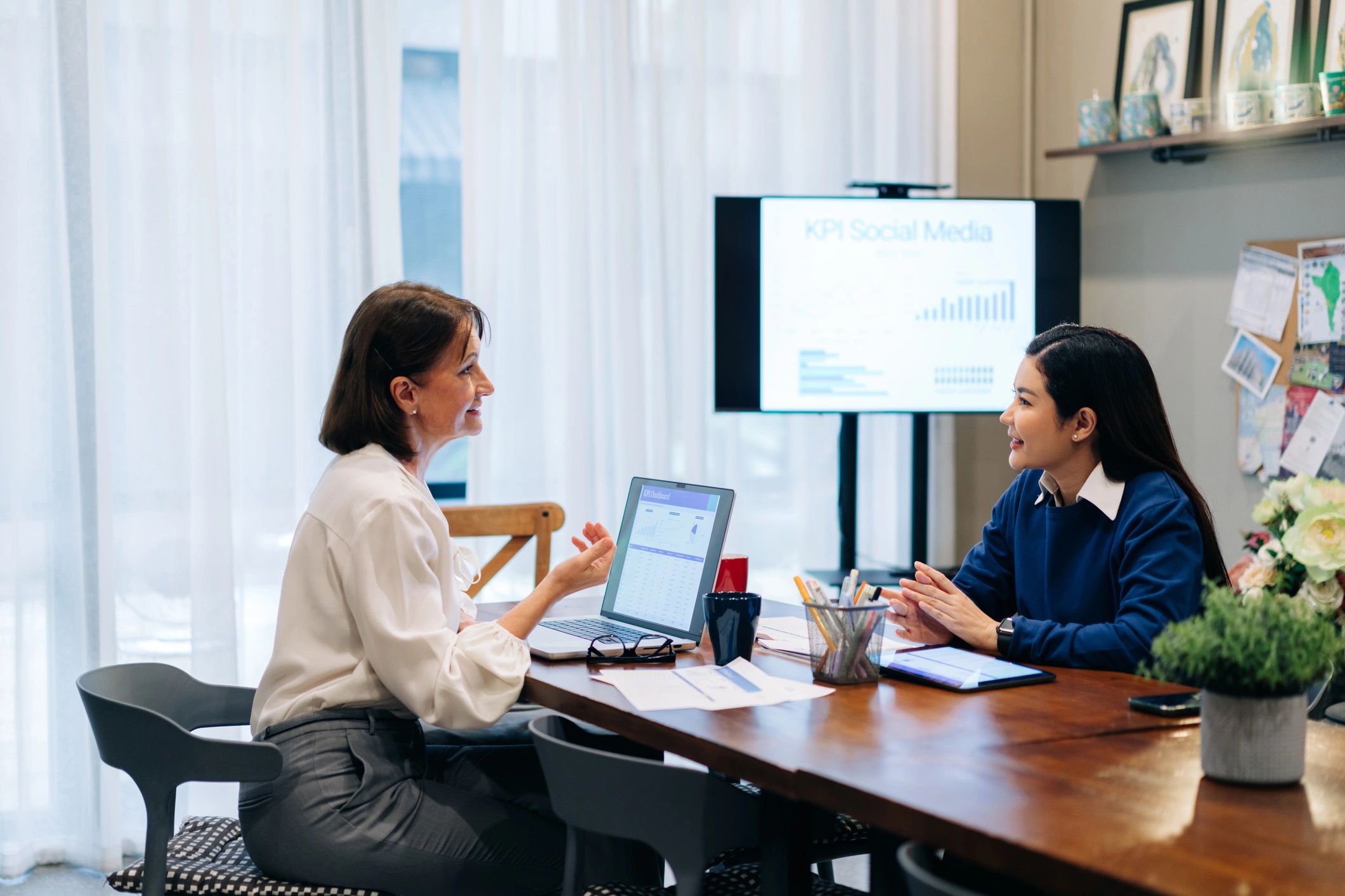 Two professionals in a focused mentorship conversation across a desk