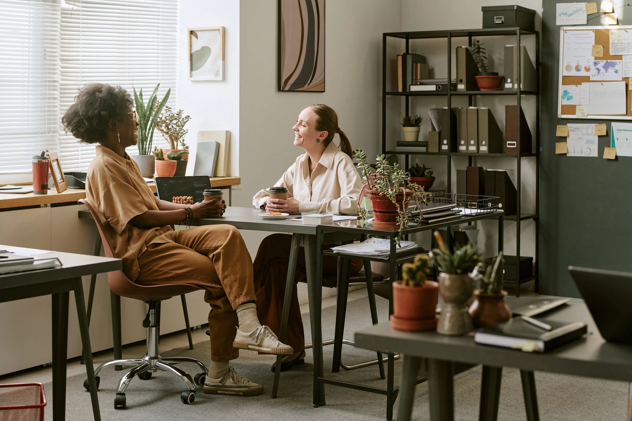 Two women collaborating in a supportive office meeting